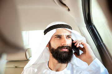 Image showing Arabian saudi businessman working in his car