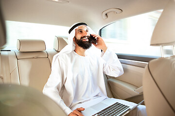 Image showing Arabian saudi businessman working in his car