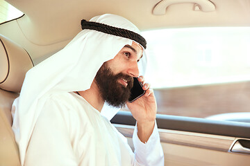 Image showing Arabian saudi businessman working in his car