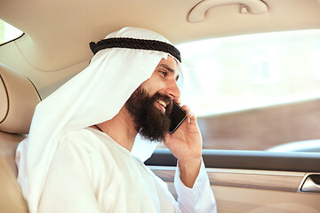 Image showing Arabian saudi businessman working in his car