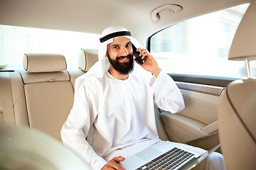 Image showing Arabian saudi businessman working in his car