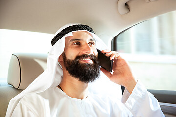 Image showing Arabian saudi businessman working in his car