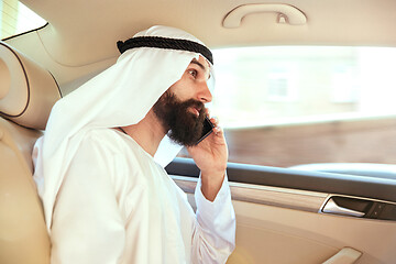 Image showing Arabian saudi businessman working in his car