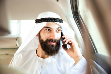 Image showing Arabian saudi businessman working in his car