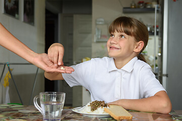 Image showing Mom gives the girl medicine to take before lunch