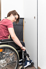 Image showing disabled woman opens a door in her flat