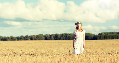 Image showing happy young woman in flower wreath on cereal field