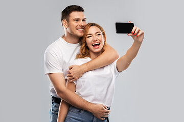 Image showing happy couple in white t-shirts taking selfie