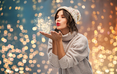 Image showing young woman in knitted winter hat sending air kiss