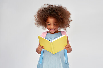 Image showing happy little african girl reading book