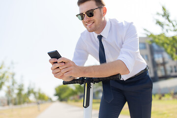 Image showing businessman with smartphone and electric scooter