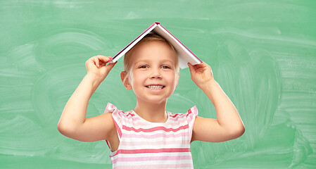 Image showing little girl with book on top of her head at school