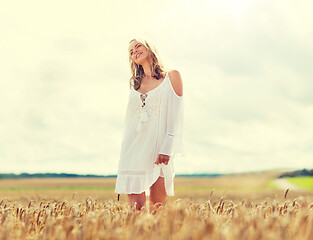 Image showing smiling young woman in white dress on cereal field