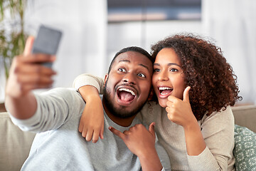 Image showing happy couple with smartphone taking selfie at home