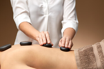 Image showing close up of woman having hot stone massage at spa