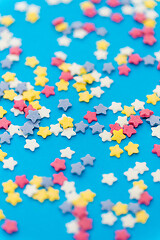 Image showing star shaped pastry sprinkles on blue background