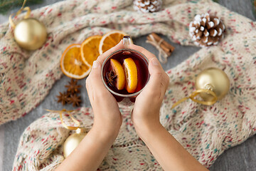 Image showing hands with glass of hot mulled wine on christmas