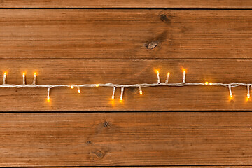 Image showing christmas garland lights on wooden background