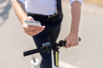 Image showing businessman with smartphone and electric scooter