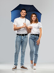 Image showing happy couple in white t-shirts with umbrella