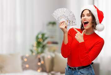 Image showing happy woman in santa hat with money on christmas