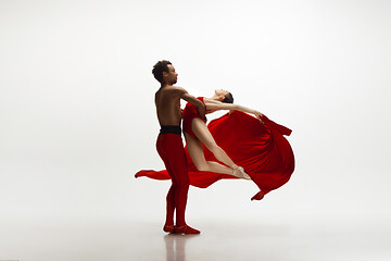 Image showing Young graceful couple of ballet dancers dancing on white studio background