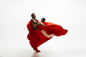 Image showing Young graceful couple of ballet dancers dancing on white studio background