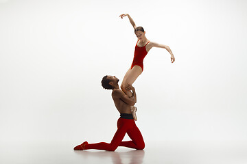 Image showing Young graceful couple of ballet dancers dancing on white studio background