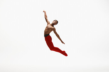 Image showing Young graceful male ballet dancer dancing on white studio background