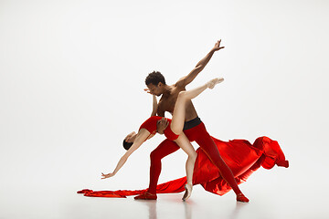 Image showing Young graceful couple of ballet dancers dancing on white studio background