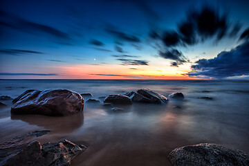 Image showing Sea sunset seascape with wet rocks