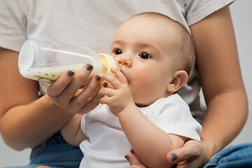 Image showing close up of mother feeding baby with milk formula