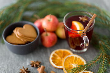 Image showing glass of hot mulled wine, cookies, apples and fir