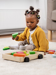 Image showing african baby girl playing with toy blocks at home