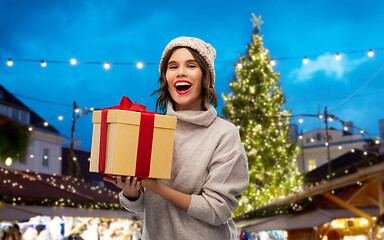 Image showing woman in hat holding gift box at christmas market