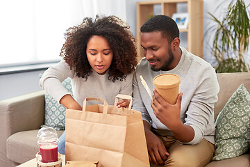 Image showing happy couple with takeaway food and drinks at home