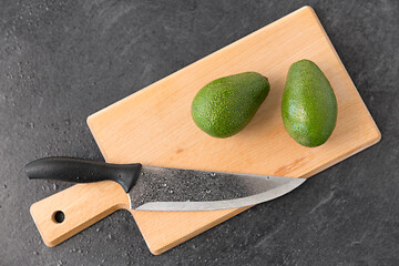 Image showing two avocados and kitchen knife on cutting board