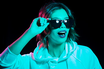 Image showing woman wearing hoodie in neon lights over black