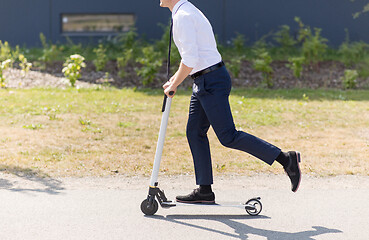 Image showing young businessman riding electric scooter outdoors