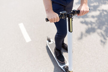 Image showing young businessman riding electric scooter outdoors