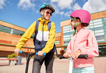 Image showing happy school children with backpacks and scooters