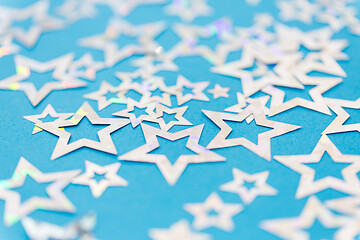 Image showing star shaped confetti decoration on blue background