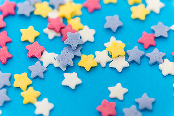 Image showing star shaped pastry sprinkles on blue background