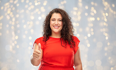 Image showing happy woman showing thumbs up over lights