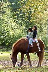 Image showing Two girls with horse