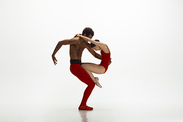 Image showing Young graceful couple of ballet dancers dancing on white studio background