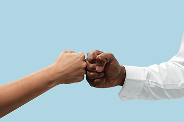 Image showing Two male hands competion in arm wrestling isolated on blue studio background