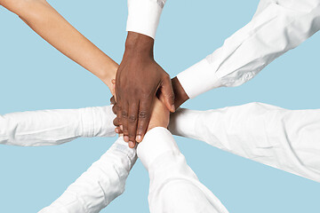 Image showing Male and female hands holding isolated on blue studio background