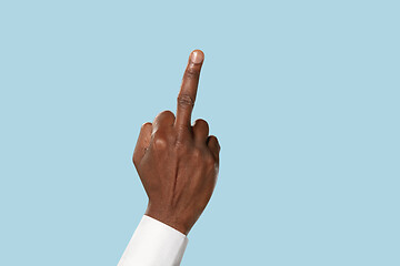 Image showing Male hand demonstrating a gesture of fuck isolated on blue background