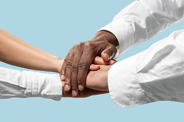 Image showing Male and female hands holding isolated on blue studio background